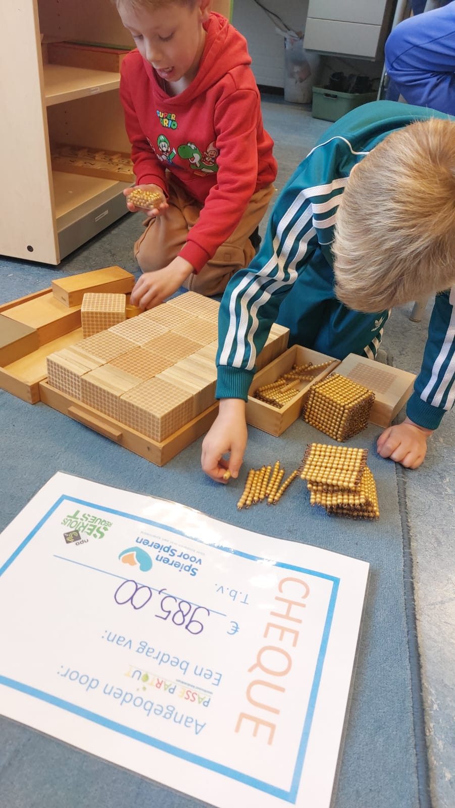 Kind aan het werk met materiaal, leerkracht observeert